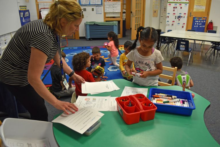 A teacher helps a student learn to write her name in a GSRP classroom in the spring of 2022.